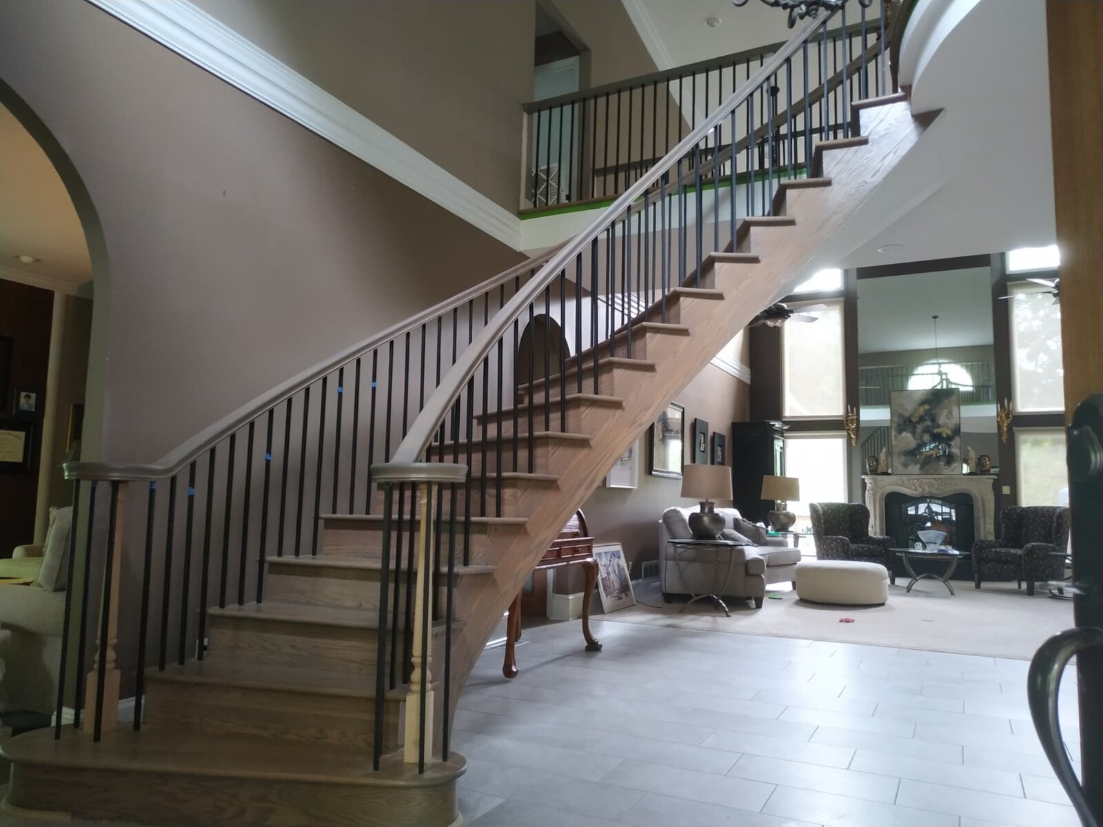 Custom curved staircase with iron railings in a finished home