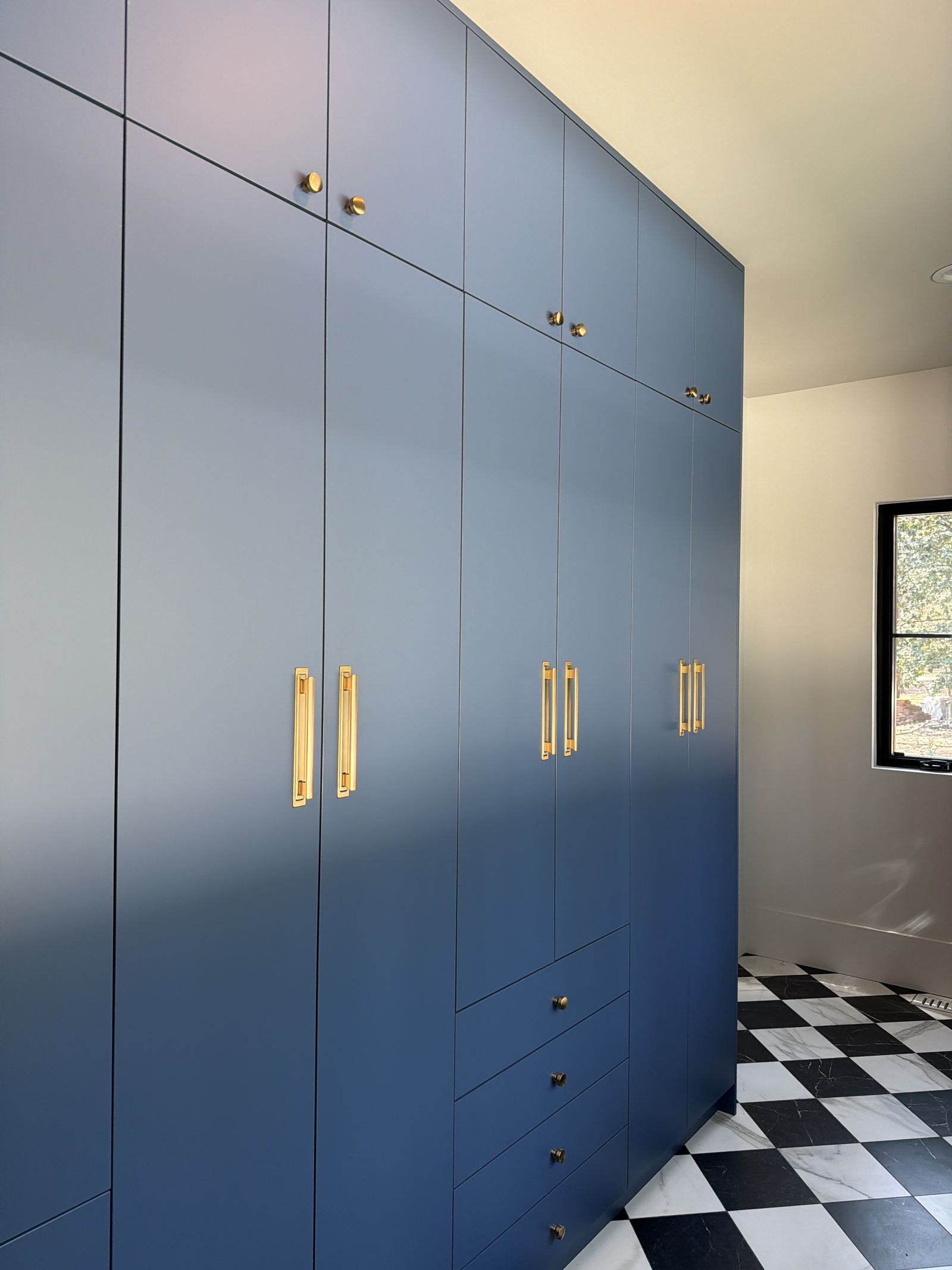 Custom blue wardrobe cabinetry with fitted interior in a finished room