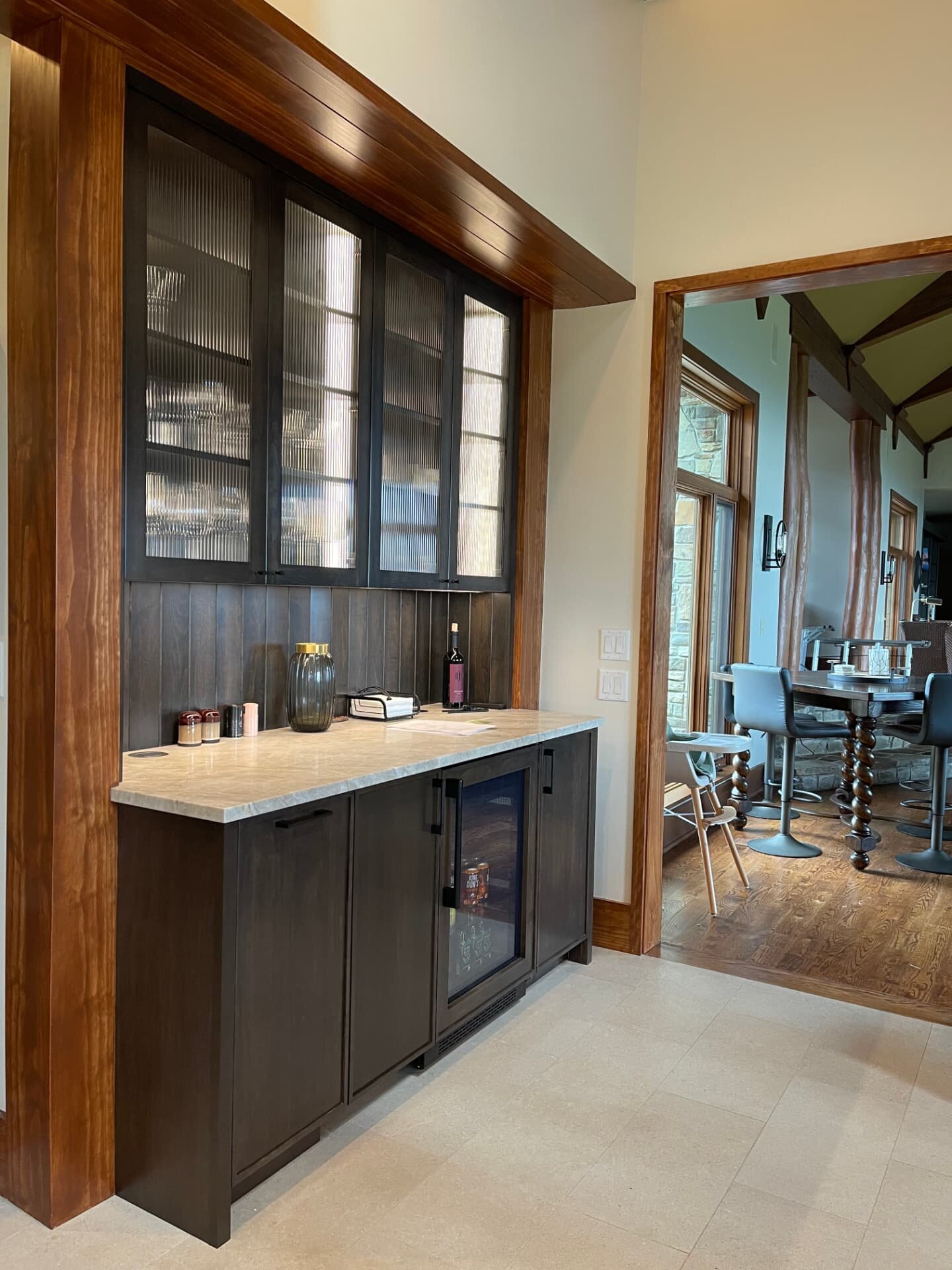 Custom built-in bar with glass-front cabinets, stone countertop and wood trim