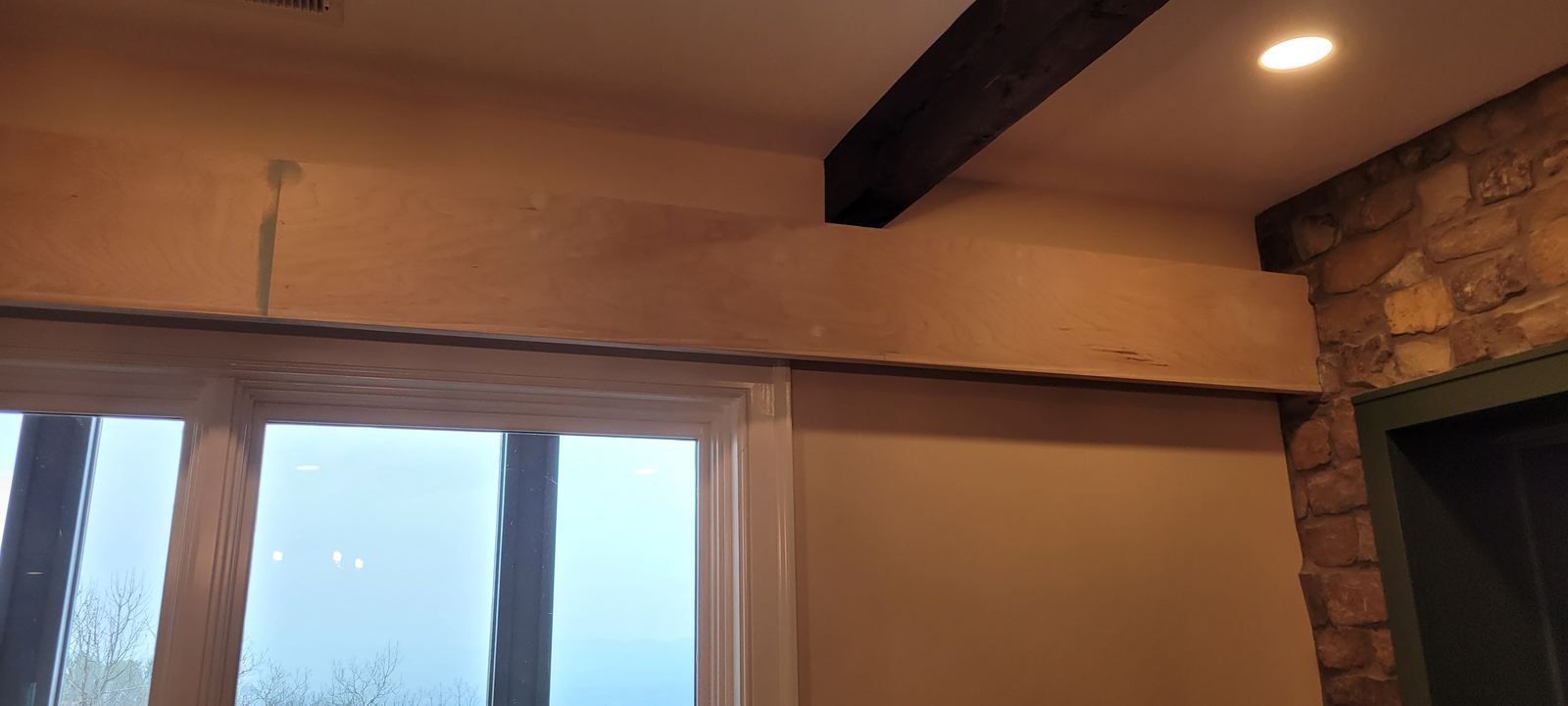 Trim and ceiling beam meeting above a window head