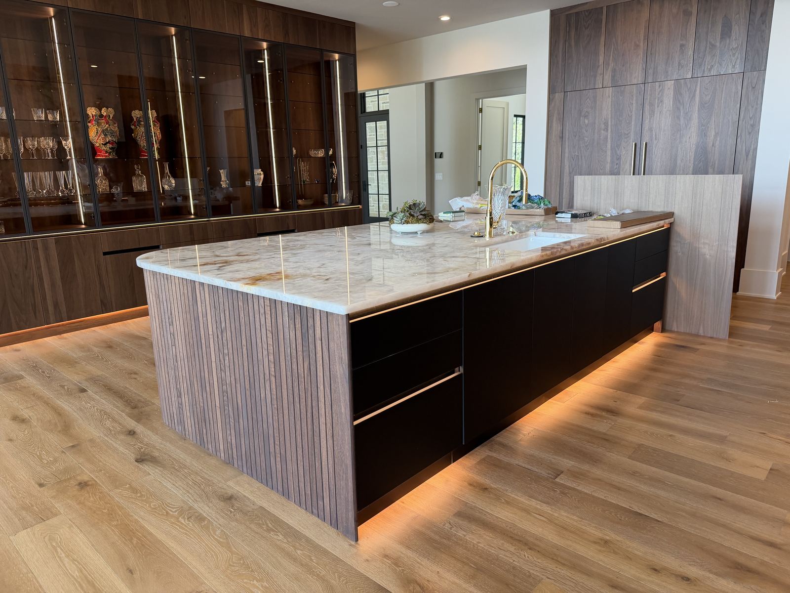 Finished custom kitchen with island, cabinetry and integrated lighting