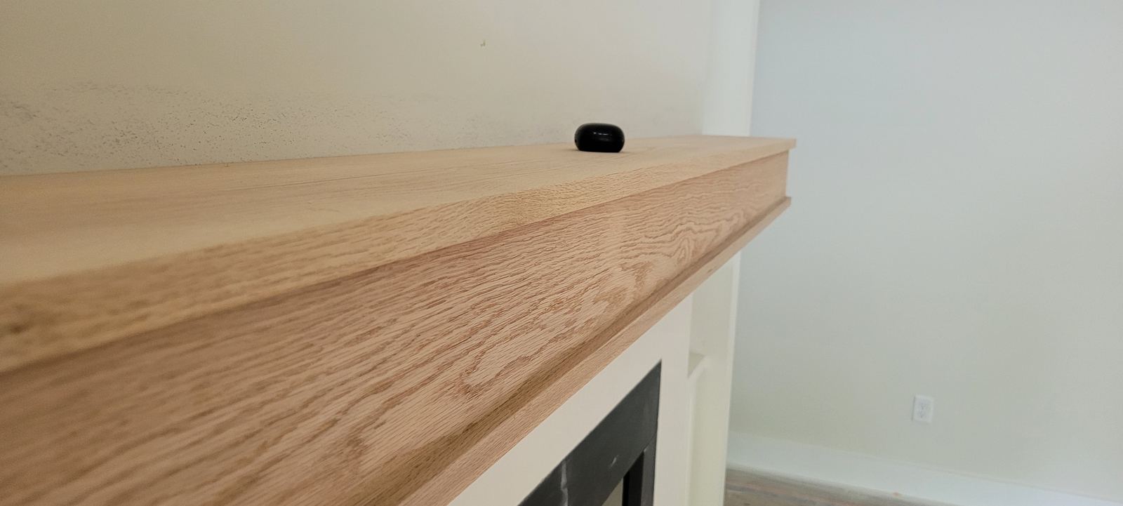 White oak mantel above a finished fireplace surround
